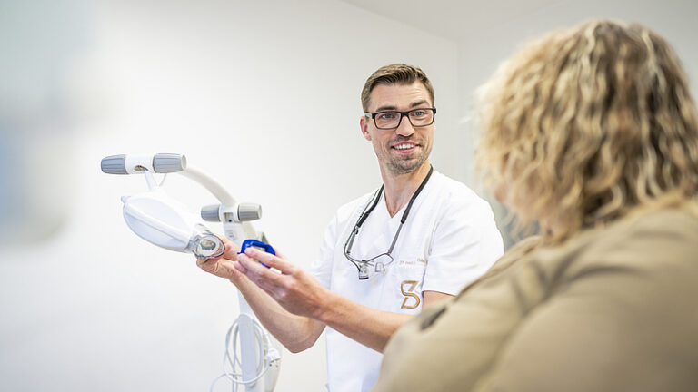 Zahnarzt bespricht professionelles Bleaching mit Patientin im Prophylaxezentrum Tiengen