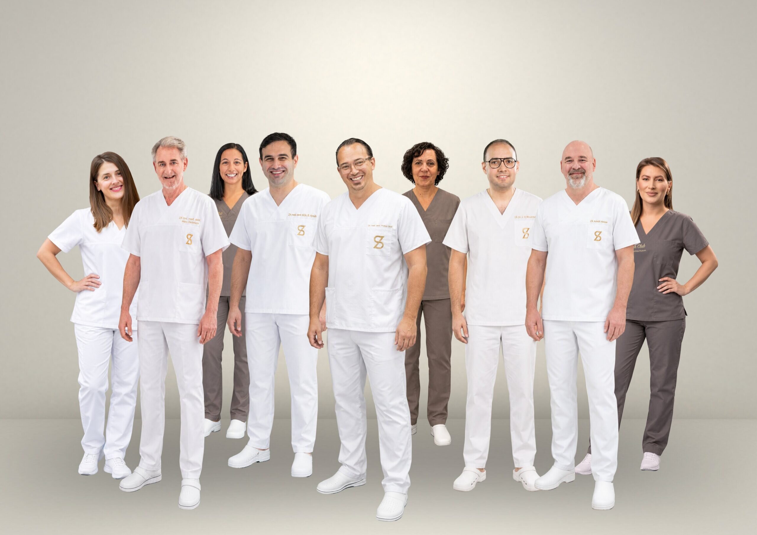 Das Team der Praxiskliniken Dr. Stoll & Kollegen in weißer und brauner Praxiskleidung